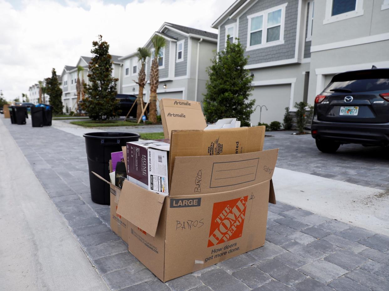 cardboard moving boxes sit in front of housing development with new homes under construction tampa florida