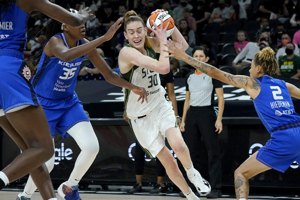 Seattle Storm forward Breanna Stewart (30) drives as Connecticut Sun guard Natisha Hiedeman (2) and forward Jonquel Jones (35) defend during the first half of the Commissioner's Cup WNBA basketball game, Thursday, Aug. 12, 2021, in Phoenix. (AP Photo/Matt York)