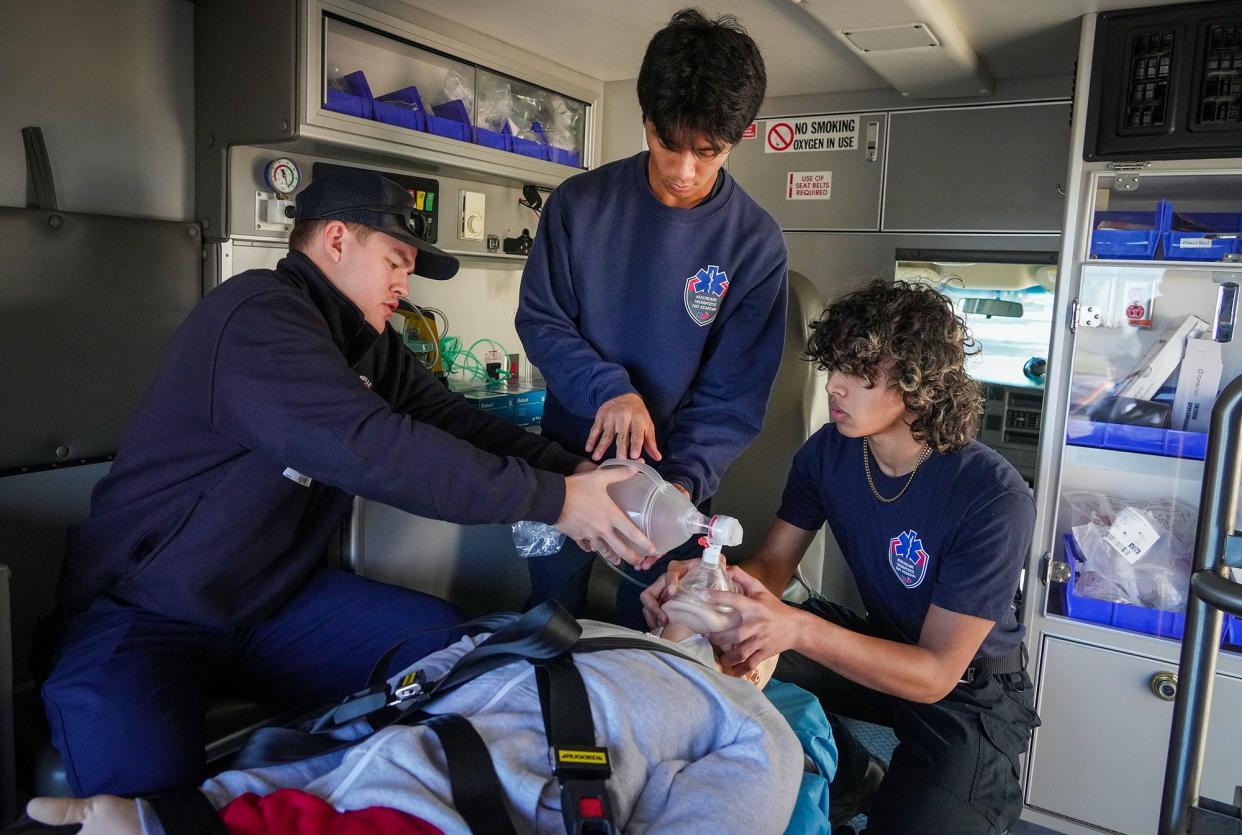 Pflugerville EMT Kevin Burke helps train students Lance Bautista and Daron Jones on how to work in ambulance. The mobile learning lab is a new addition to the Fire and EMT academies, a partnership between the Pflugerville school district and Travis County ESD No. 2.