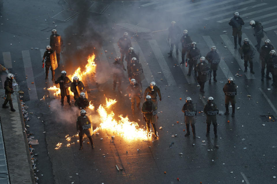 A molotov cocktail explodes next to Greek riot police during clashes after a rally in Athens, Sunday, Jan. 20, 2019. Greece's Parliament is to vote this coming week on whether to ratify the agreement that will rename its northern neighbor North Macedonia. Macedonia has already ratified the deal, which, polls show, is opposed by a majority of Greeks. (AP Photo/Thanassis Stavrakis)