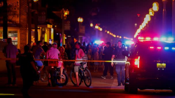 PHOTO: Beachgoers are seen next to law enforcement officers on a crime scene as they respond to a shooting at Hollywood Beach on May 29, 2023 in Hollywood, Florida. (Eva Marie Uzcategui/Getty Images)