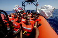 African migrants wave after being rescued by the MV Geo Barents vessel of MSF (Doctors Without Borders), off Libya in the central Mediterranean route, Monday, Sept. 20, 2021. (AP Photo/Ahmed Hatem)