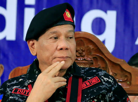 Philippine President Rodrigo Duterte, wearing a military uniform, gestures as he attends the 67th founding anniversary of the First Scout Ranger regiment in San Miguel town, Bulacan province, north of Manila, Philippines November 24, 2017. REUTERS/Romeo Ranoco