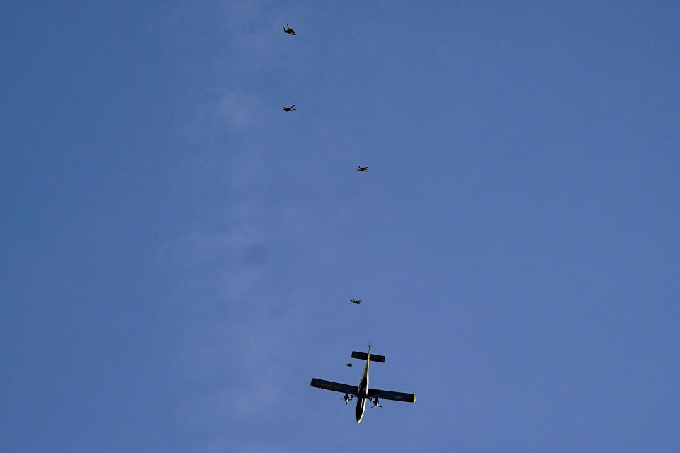 The U.S. Army Parachute Team the Golden Knights jump out of their aircraft before a baseball game between the Washington Nationals and the Arizona Diamondbacks at Nationals Park, Wednesday, April 20, 2022, in Washington. The U.S. Capitol was briefly evacuated after police said they were tracking an aircraft “that poses a probable threat,” but the plane turned out to be the military aircraft with people parachuting out of it for a demonstration at the Nationals game, officials told The Associated Press. (AP Photo/Alex Brandon)