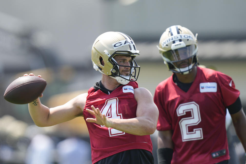 New Orleans Saints quarterback Derek Carr passes as quarterback Jameis Winston (2) watches during an NFL football practice in Metairie, La., Tuesday, May 23, 2023. (AP Photo/Gerald Herbert)