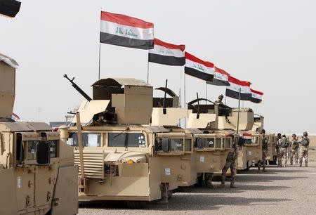 Iraqi security forces ride in vehicles travelling to Mosul to fight against militants of Islamic State at an Iraqi army base in Camp Taji in Baghdad, February 21, 2016. REUTERS/Ahmed Saad