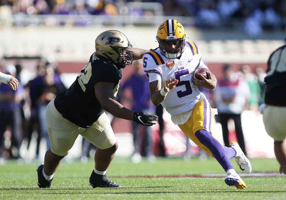 ORLANDO, FL - JANUARY 02: LSU Tigers quarterback Jayden Daniels (5) runs the ball and gets brought down by Purdue Boilermakers defensive tackle Mo Omonode (92) during the Cheez-It Citrus Bowl on January 2, 2023 at Camping World Stadium in Orlando, FL. (Photo by Russell Lansford/Icon Sportswire via Getty Images)