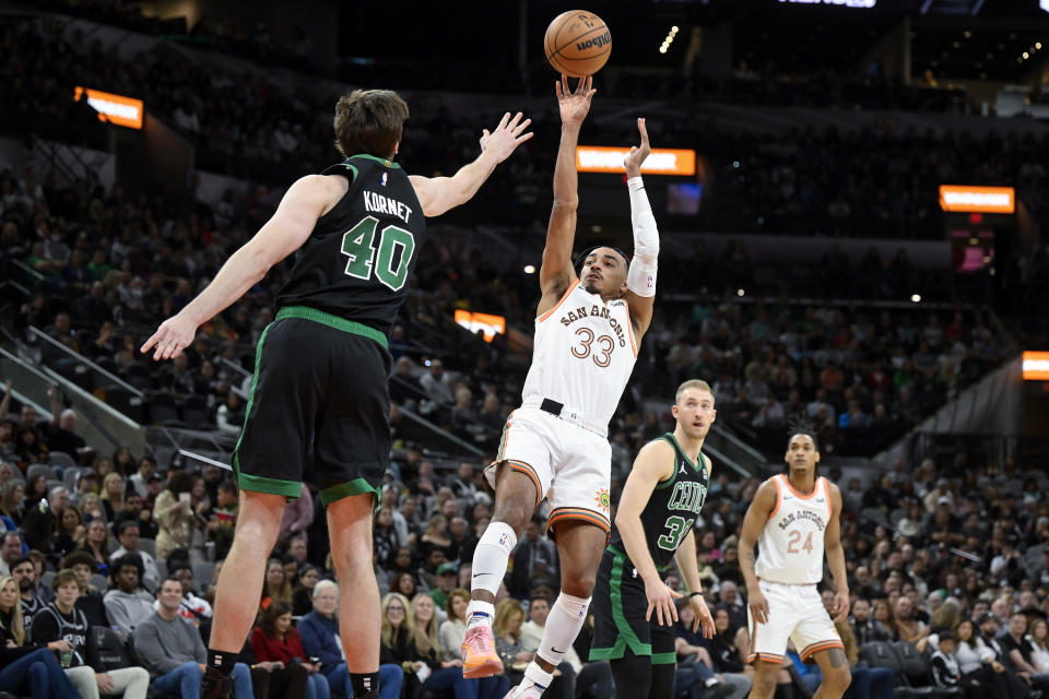 San Antonio Spurs' Tre Jones (33) shoots against Boston Celtics' Luke Kornet (40) during the first half of an NBA basketball game, Sunday, Dec. 31, 2023, in San Antonio. (AP Photo/Darren Abate)