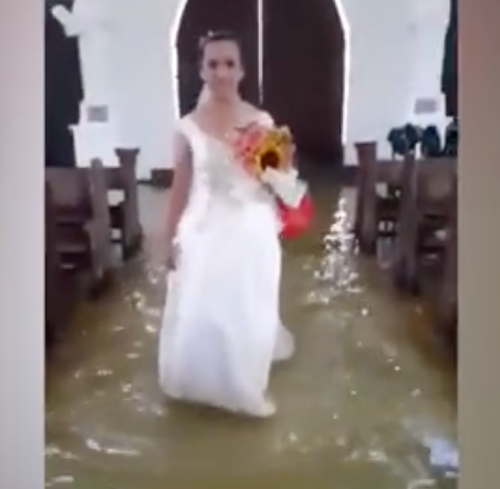 Jobel Delos Angeles didn’t let a flooded church stop her wedding. Photo: Storyful