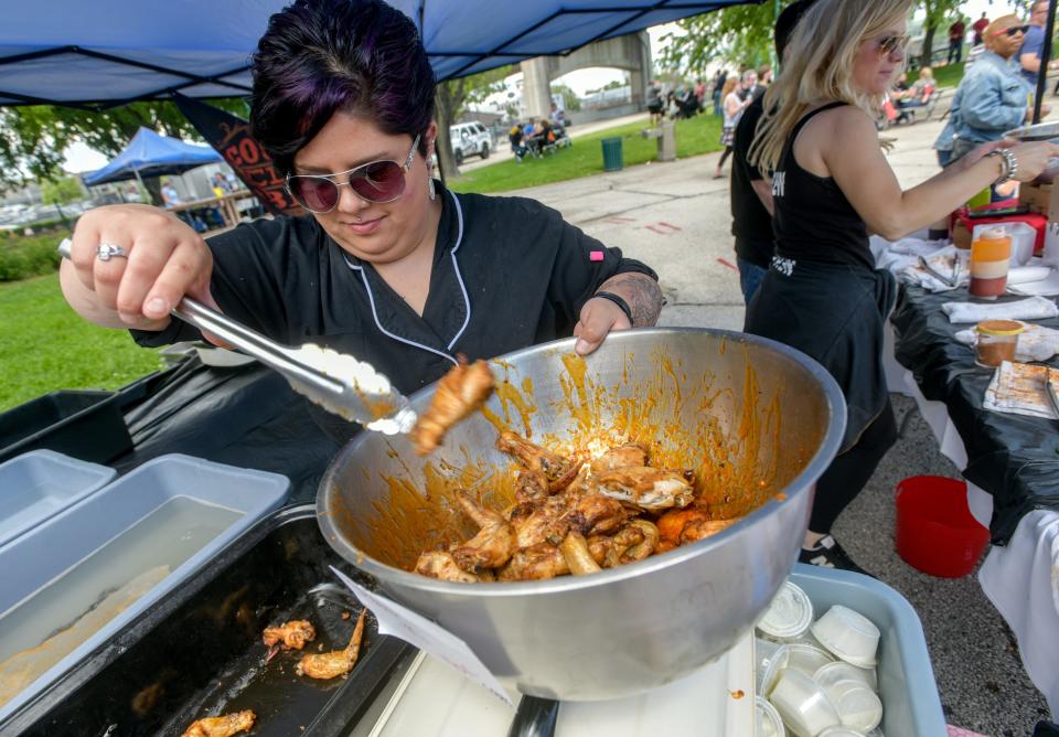 Kristen Delbo, a chef at Country Club BBQ on Farmington Road, scoops up a bowl of chicken wings at their WingFest 2019 booth on Sunday, May 19, 2019 on the Peoria riverfront. [MATT DAYHOFF/JOURNAL STAR]