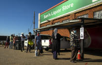 Customers queue to purchase alcoholic beverages outside the Sam Liquor Store in Thokoza township, near Johannesburg, South Africa, Monday, June 1, 2020. Liquor stores have reopened Monday after being closed for over two months under lockdown restrictions in a bid to prevent the spread of coronavirus. (AP Photo/Themba Hadebe)
