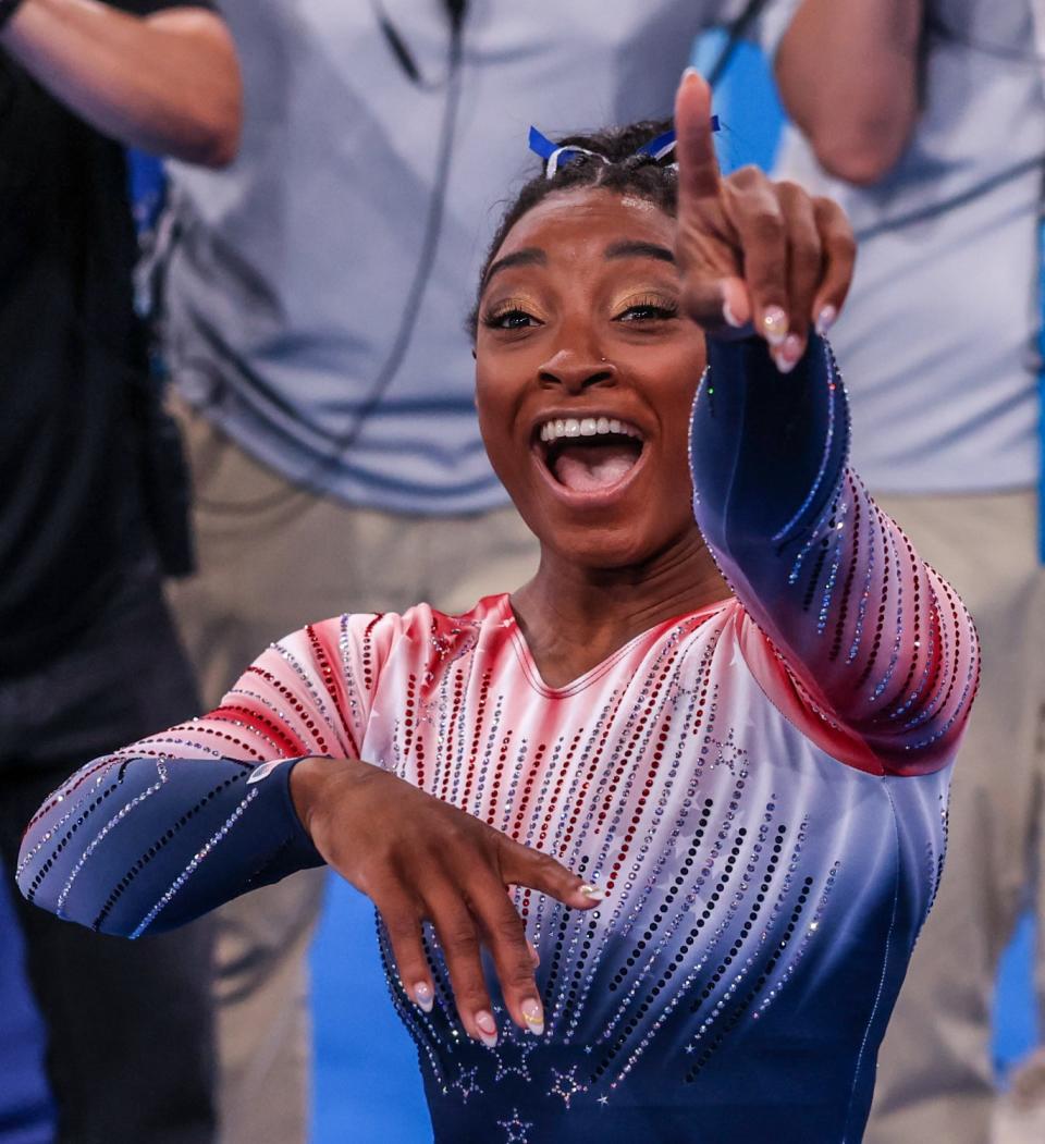 Simone Biles points and smiles.