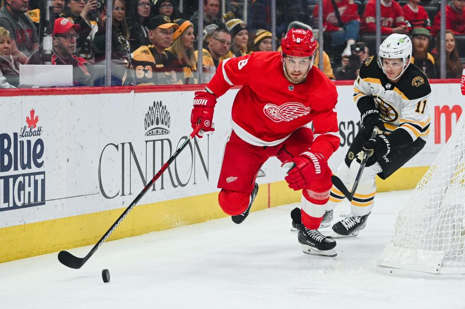 Detroit Red Wings defenseman Ben Chiarot (8) and Boston Bruins center Trent Frederic (11) battle for the puck during the first period at Little Caesars Arena, March 12, 2023.