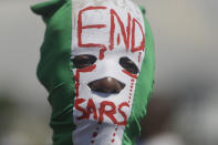 People demonstrate on the street to protest against police brutality, in Lagos, Nigeria, Sunday Oct. 18, 2020. Nigerian protests against police brutality continued Sunday for the eleventh day, with demonstrators fending off attacks from gangs suspected to be backed by the police, warnings from the Nigerian military, and a government order to stop because of COVID-19. (AP Photo/Sunday Alamba)