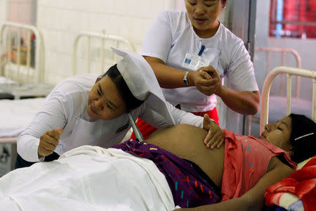 A midwife listens to a baby's movement through a pregnant woman's belly in Central Women's Hospital in Yangon, Myanmar March 17, 2017. Picture taken on March 17, 2017. REUTERS/Pyay Kyaw Aung