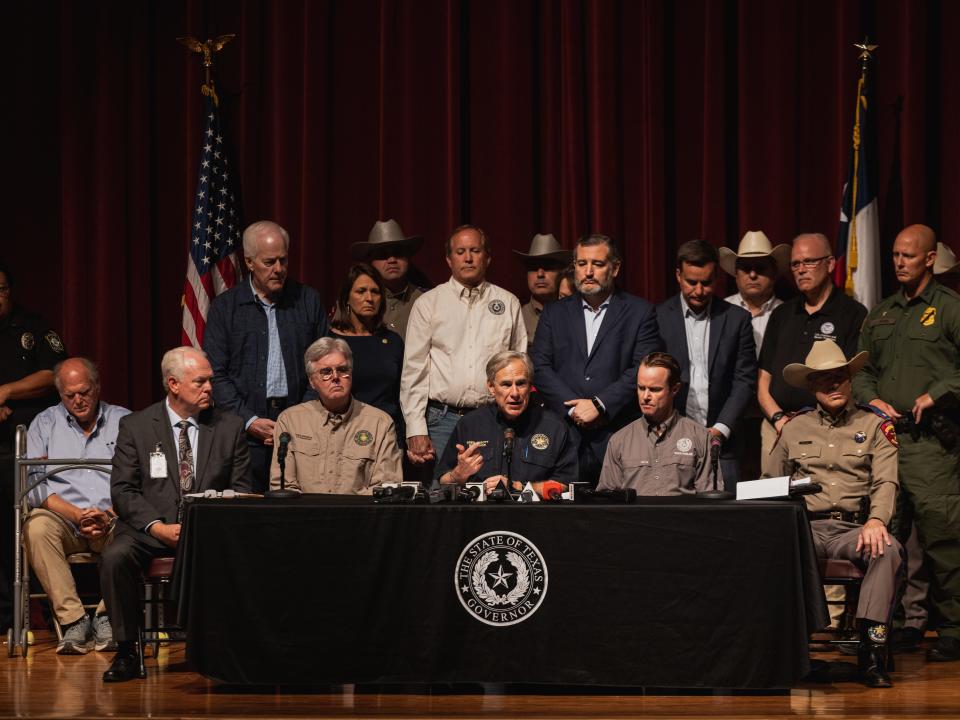 Texas officials sit on a stage giving a press conference.