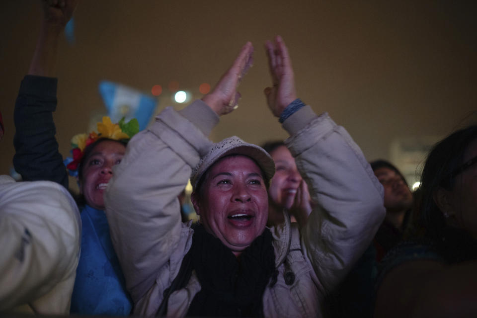 People celebrate as they watch the inauguration ceremony of incoming Guatemalan President Bernardo ArÈvalo on a screen outside the National Palace in Guatemala City, early Monday, Jan. 15, 2024. (AP Photo/ Santiago Billy)
