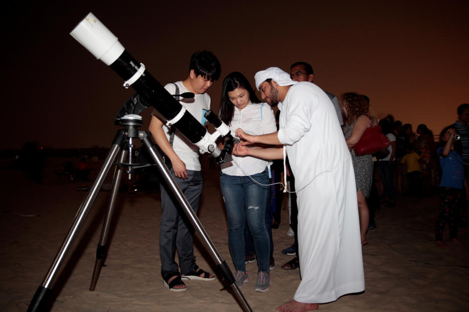 An Emirati man uses a telescope to take a picture of the lunar eclipse of a full "Blood Moon" at Al Sadeem Observatory in Al Wathba near Abu Dhabi. (Photo: Christopher Pike / Reuters)