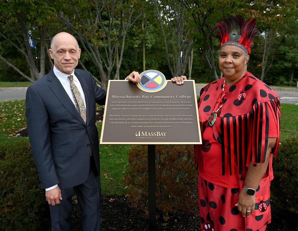 Dr. Denise Pruitt, right, program chair for health studies at MassBay Community College, and MassBay president David Podell show off the the land acknowledgement plaque that honors the indigenous people whose land MassBay sits on, Oct. 18, 2022. Pruitt is also known as Chief Ladybug of the Croatan tribe. The plaque was unveiled last month.