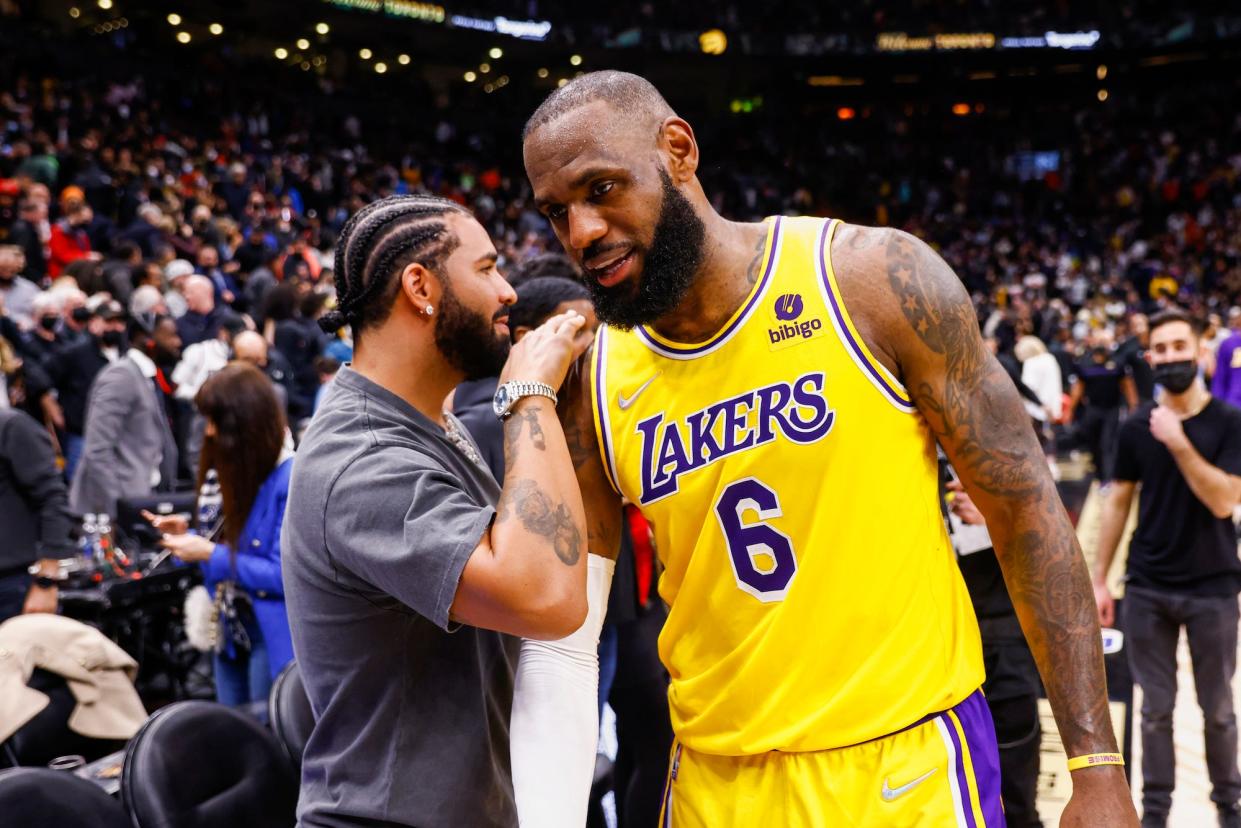 LeBron James #6 of the Los Angeles Lakers talks to rapper Drake after the game against the Toronto Raptors on March 18, 2022 at the Scotiabank Arena.