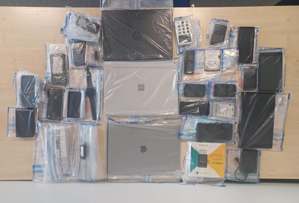 Phones, laptops and tablets seized by the police as part of the investigation. (Metropolitan Police/PA)

