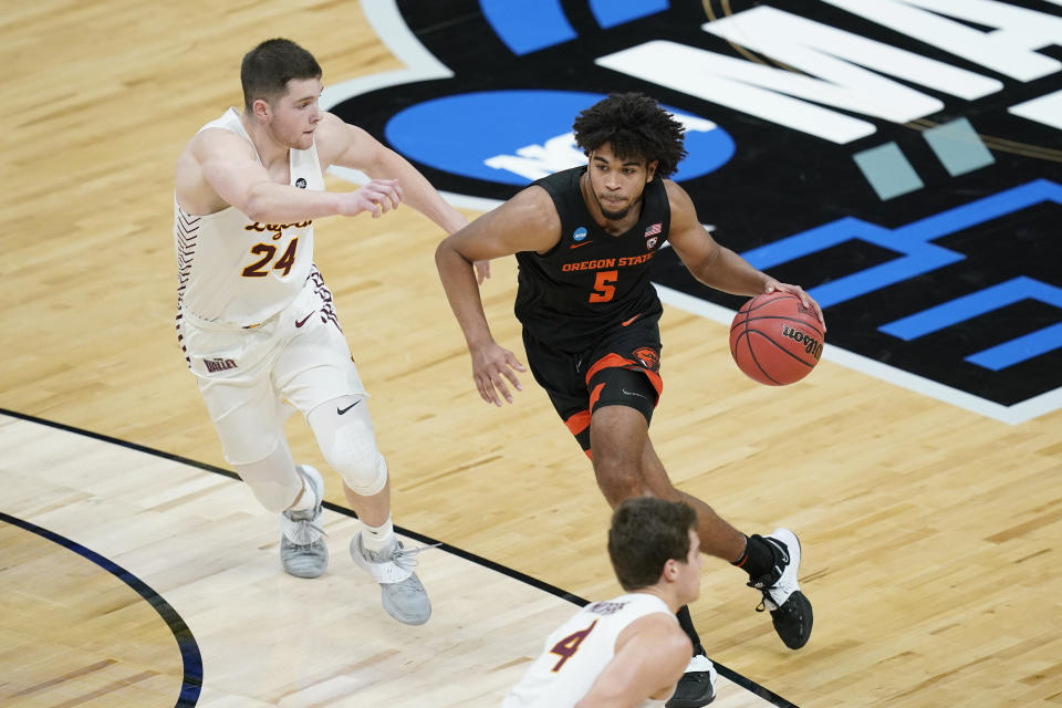 Oregon State guard Ethan Thompson (5) drives past Loyola Chicago guard Tate Hall (24) during the first half of a Sweet 16 game in the NCAA men's college basketball tournament at Bankers Life Fieldhouse, Saturday, March 27, 2021, in Indianapolis. (AP Photo/Darron Cummings)