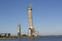 The smokestack at the former B.L. England Generating Station, a coal and oil burning power plant in Upper Township, N.J., is toppled during a control demolition on Thursday, October 26, 2023. The site will be redeveloped as a mixed-use residential and commercial project, and a nearby electrical substation will be used to connect New Jersey's soon-to-come offshore wind farms with the electrical grid. (AP Photo/Ted Shaffrey)