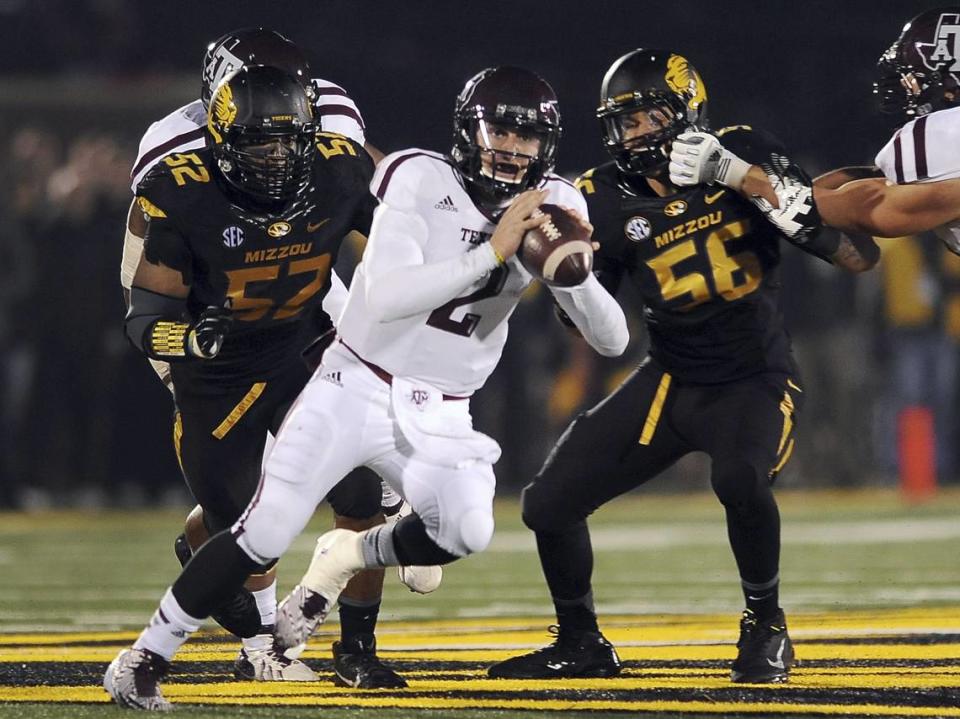 Texas A&M quarterback Johnny Manziel, center, scrambles as Missouri defensive linemen Michael Sam, left, and Shane Ray defend during the second quarter of an NCAA college football game on Saturday, Nov. 30, 2013, in Columbia, Mo. (AP Photo/L.G. Patterson)