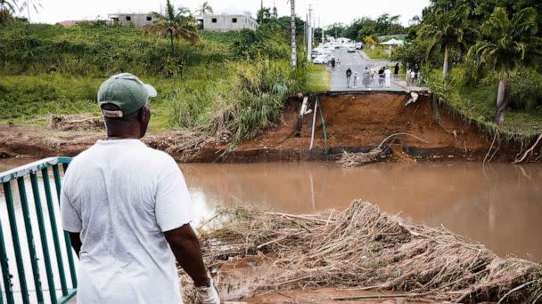 PHOTO: A pedestrian looks at a destroyed bridge after the passage of Fiona storm at the Pont de Goyave, on the French island of Guadeloupe, on Sept. 18, 2022. (Carla Bernhardt/AFP via Getty Images)