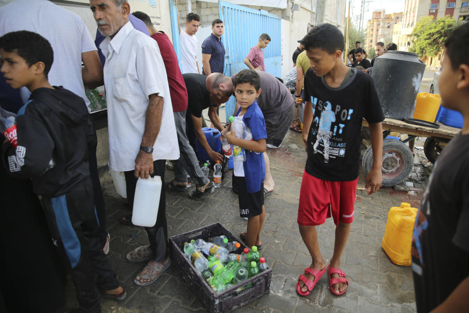 Palestinians collect water in Nuseirat camp in the central Gaza Strip during ongoing Israeli bombardment on Tuesday, Oct. 17, 2023. (AP Photo/Ali Mohmoud)