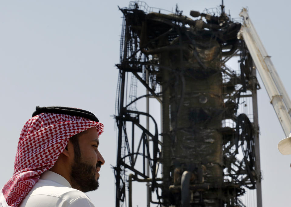 In this photo opportunity during a trip organized by Saudi information ministry, a man watches the damaged in the Aramco's Khurais oil field, Saudi Arabia, Friday, Sept. 20, 2019, after it was hit during Sept. 14 attack. Saudi officials brought journalists Friday to see the damage done in an attack the U.S. alleges Iran carried out. (AP Photo/Amr Nabil)
