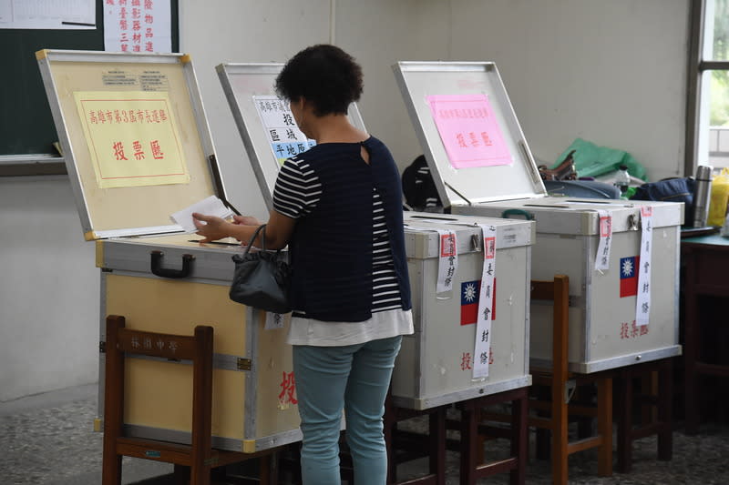 九合一選舉與10案公投24日投開票，民眾上午前往高雄林園中學投開票所投票，將市長票投入票匭。中央社記者王飛華攝　107年11月24日