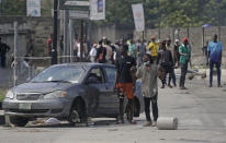 People protest against alleged police brutality near to the Lekki toll gate in Lagos, Nigeria, Wednesday Oct. 21, 2020. After 13 days of protests against alleged police brutality, authorities have imposed a 24-hour curfew in Lagos, Nigeria's largest city, as moves are made to stop growing violence. ( AP Photo/Sunday Alamba)