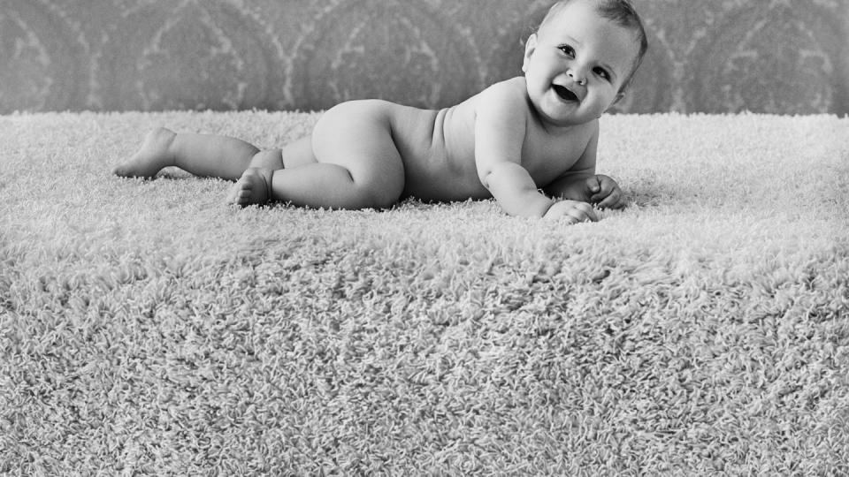 baby boy lying on rug, smiling