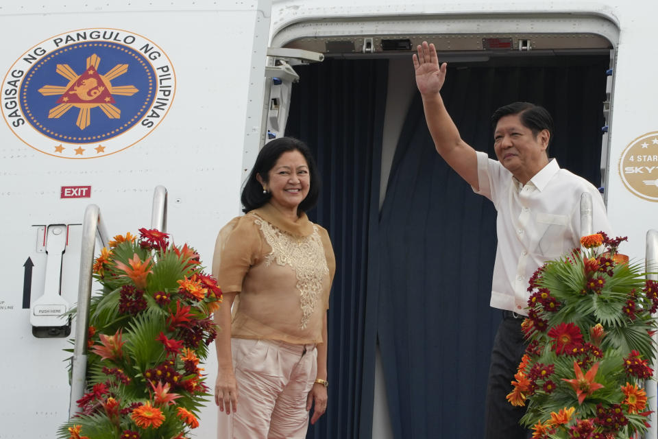 Philippine President Ferdinand Marcos Jr., right, waves beside wife Maria Louise as they board a plane for China on Tuesday, Jan. 3, 2023, at the Villamor Air Base in Manila, Philippines. (AP Photo/Aaron Favila)