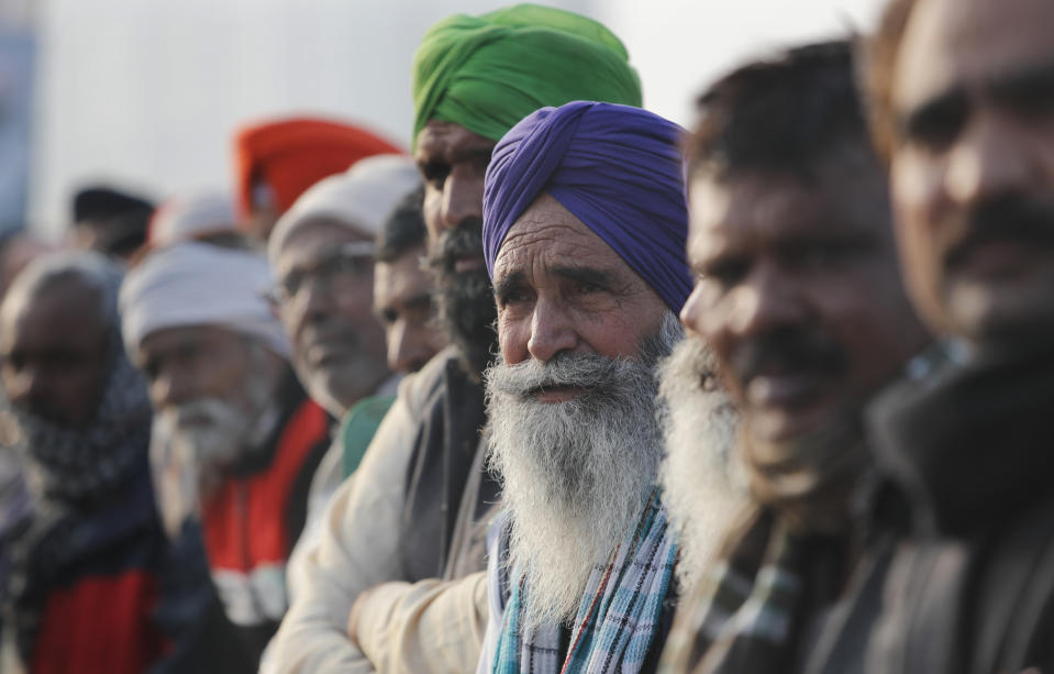 Indian Farmers listen to their leader as they continue to block highway leading to Delhi in protest against new farm laws, at Delhi-Uttar Pradesh border, India, Friday, Jan. 22, 2021. Talks between protesting farmers’ leaders and the government ended abruptly in a stalemate on Friday with the agriculture minister saying he has nothing more to offer than suspending contentious agricultural laws for 18 months. The farmers’ organizations in a statement on Thursday said they can’t accept anything except the repeal of the three new laws. (AP Photo/Manish Swarup)