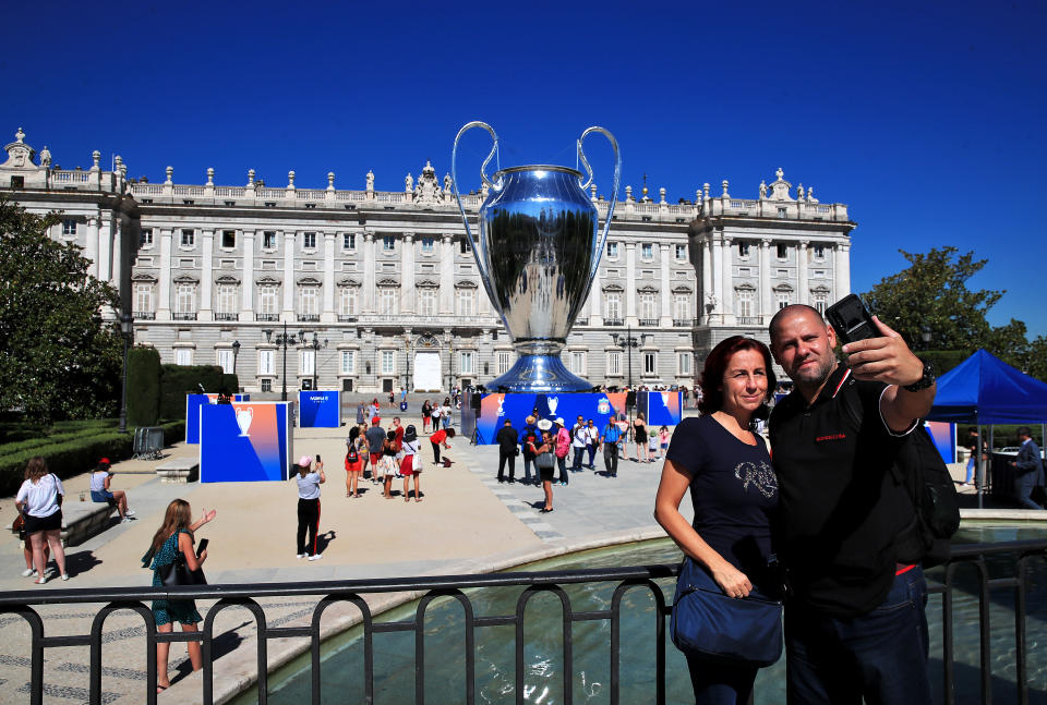 People take a photograph in front of a giant replica Champions League trophy at Plaza de Oriente in Madrid, Spain.