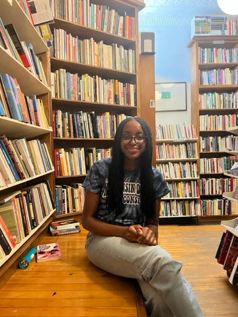 Youth Poet Laureate Emily Igwike sits in a corner of the Woodland Pattern Bookstore.