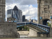 Tower Bridge crossing the River Thames is stuck open, leaving traffic in chaos as the iconic river crossing remains open, in London, Saturday Aug. 22, 2020. The historic bridge has failed to close Saturday after opening to allow ships to pass underneath on the River Thames. The Gherkin building in the financial district of London, front centre left. (AP Photo / Tony Hicks)