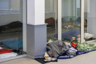 Migrants sleep on the floor of a squatted building in Brussels, Tuesday, Jan. 31, 2023. Many refugees and asylum-seekers are literally left out in the cold for months as the European Union fails to get its migration system working properly. And most talk is about building fences and repatriation instead of working to improve a warm embrace for people fleeing nations like Afghanistan where the Taliban has taken over. (AP Photo/Olivier Matthys)