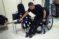 22-year-old Errol Samuels from Queens, New York, who lost the use of his legs in 2012 after a roof collapsed onto him at an off-campus house party near where he was attending college in upstate New York, lifts himself from his wheelchair into a ReWalk electric powered exoskeletal suit for a therapy session at the Mount Sinai Medical Center in New York City March 26, 2014. Made by the Israeli company Argo Medical Technologies, ReWalk is a computer controlled device that powers the hips and knees to help those with lower limb disabilities and paralysis to walk upright using crutches. Allan Kozlowski, assistant professor of Rehabilitation Medicine at Icahn School of Medicine at Mount Sinai hospital, where patients like Samuels are enrolled in his clinical trials of the ReWalk and another exoskeleton, the Ekso (Ekso Bionics) hopes machines like these will soon offer victims of paralysis new hope for a dramatically improved quality of life and mobility. The ReWalk is currently only approved by the U.S. Food and Drug Administration (FDA) for use in rehabilitation facilities like at Mount Sinai, as they weigh whether to approve the device for home use as it already is in Europe. Picture taken March 26, 2014. REUTERS/Mike Segar