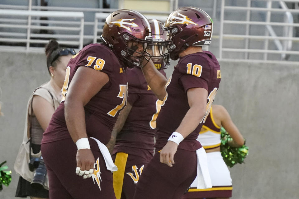 Arizona State Sun Devils offensive lineman Leif Fautanu, left, celebrates with quarterback Sam Leavitt (10) after they scored against the Kansas during the first half of an NCAA college football game Saturday, Oct. 5, 2024, in Tempe, Ariz. (AP Photo/Darryl Webb)