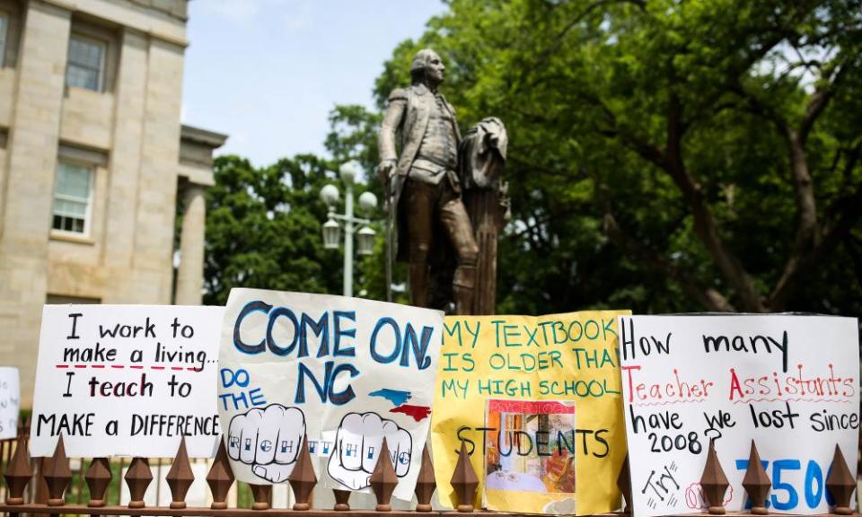 Teachers placed protest signs around a statue of George Washington outside the state capitol building in Raleigh, North Carolina on 16 May 2018. 