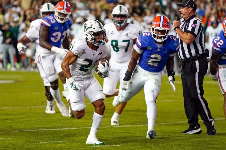 South Florida running back Brian Battie, front left, runs past Florida linebacker Amari Burney (2) for a 10-yard touchdown during the first half of an NCAA college football game, Saturday, Sept. 17, 2022, in Gainesville, Fla. (AP Photo/John Raoux)