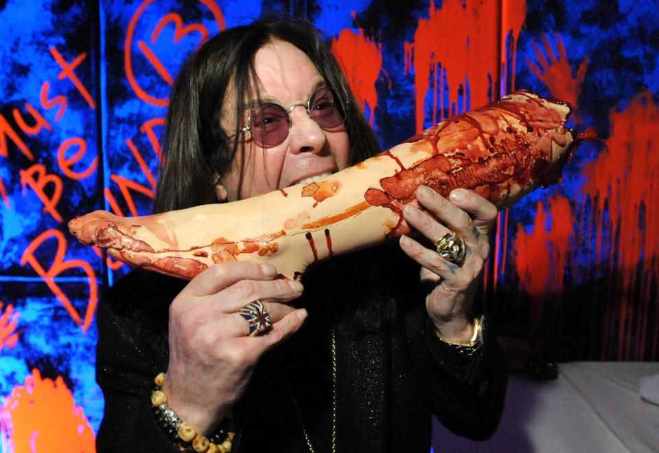 In this Tuesday, Sept. 17, 2013 photo, Ozzy Osbourne poses with a prop at the "Black Sabbath: 13 3D" maze at Universal Studios Halloween Horror Nights, in Universal City, Calif. Several spooks at this year's Halloween Horror Nights are hyping new releases from the entertainment industry. Besides "13" from Sabbath, there's a "scare zone" populated by actors dressed as the nasty Chucky doll from the direct-to-DVD sequel "Curse of Chucky," and a new maze incorporating supernatural elements from the "Insidious" films. (Photo by John Shearer/Invision/AP)