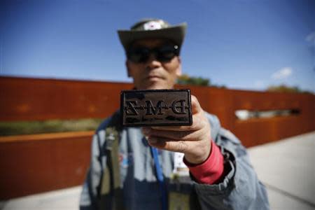 A tour guide poses for photographs with a stamp for tourists at the Imjingak pavilion near the demilitarized zone which separates the two Koreas, in Paju, north of Seoul October 16, 2013. REUTERS/Kim Hong-Ji