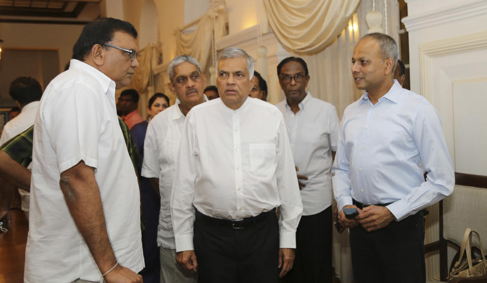 Sri Lanka's sacked prime minister Ranil Wickremesinghe, center, speaks with party members at his official residence in Colombo, Sri Lanka, Friday, Oct. 26, 2018. Sri Lankan President Maithripala Sirisena has sacked the country's prime minister and replaced him with a former strongman, state television said Friday. (AP Photo/Rukmal Gamage)