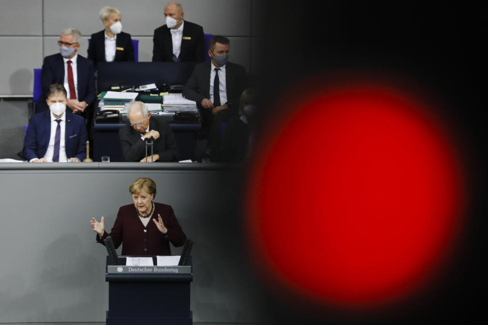 German Chancellor Angela Merkel delivers a speech about German government's policies to combat the spread of the coronavirus and COVID-19 disease at the parliament Bundestag, in Berlin, Germany, Thursday, Nov. 26, 2020. Merkel and the country's 16 state governors have agreed to extend a partial shutdown well into December in an effort to further reduce the rate of coronavirus infections ahead of the Christmas period. (AP Photo/Markus Schreiber)