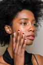 <p>Julie Kandalec for Essie created a dramatic crescent French manicure to play off the ’70s feel of the collection. Three shades were used: Go Overboard, Bahama Mama, and Smokin’ Hot. (Photo: Imaxtree) </p>