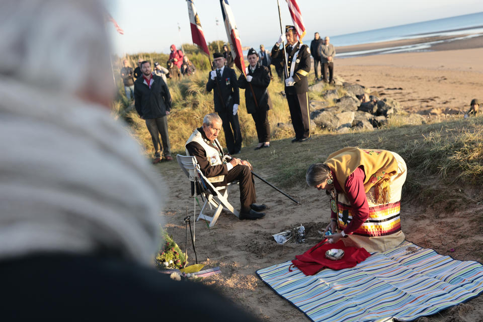 WWII veteran Charles Shay, 97, and Julia Kelly, a Gulf war veteran, pay tribute to soldiers during a D-Day commemoration ceremony of the 78th anniversary for those who helped end World War II, in Saint-Laurent-sur-Mer, Normandy, France, Monday, June 6, 2022. (AP Photo/Jeremias Gonzalez)